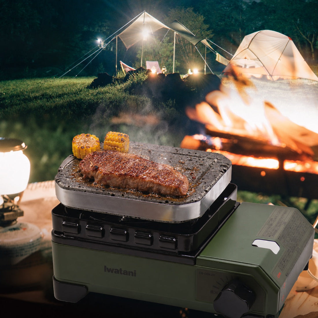 キャンプでカセットコンロにのせた溶岩プレートで焼くステーキ