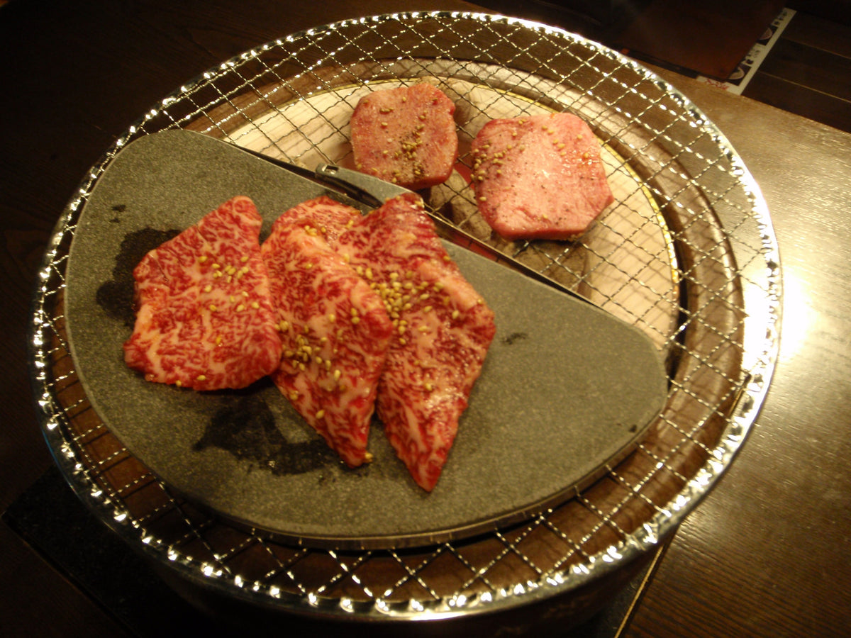 丸い溶岩プレートの上の牛肉（炭火の網の上）